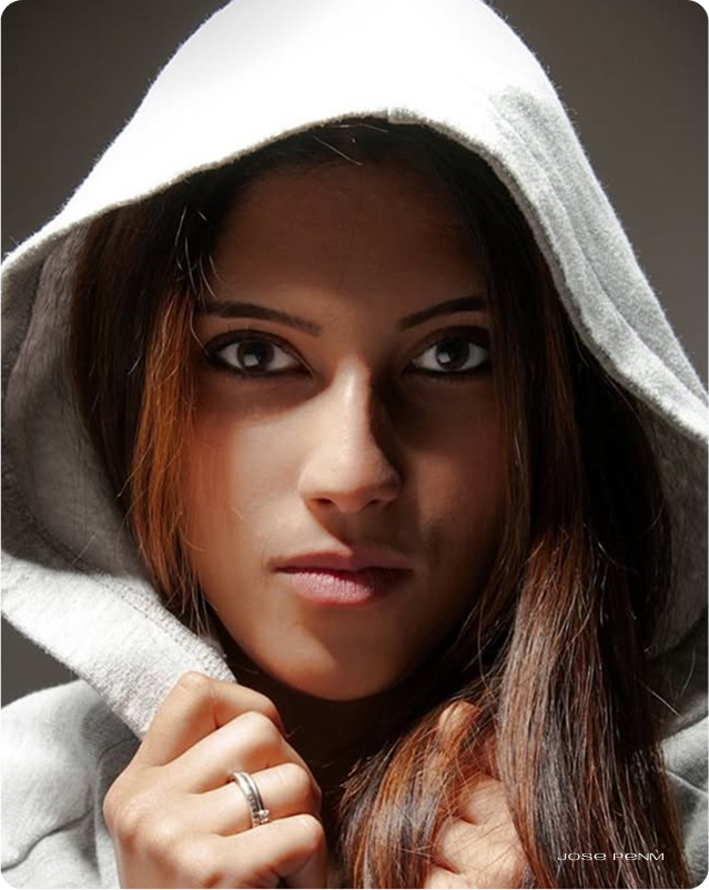 Woman wearing a hooded garment with a neutral background