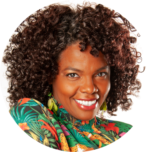 Woman with curly hair wearing a colorful patterned top on a white background
