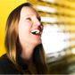 Woman laughing with a blurred yellow background