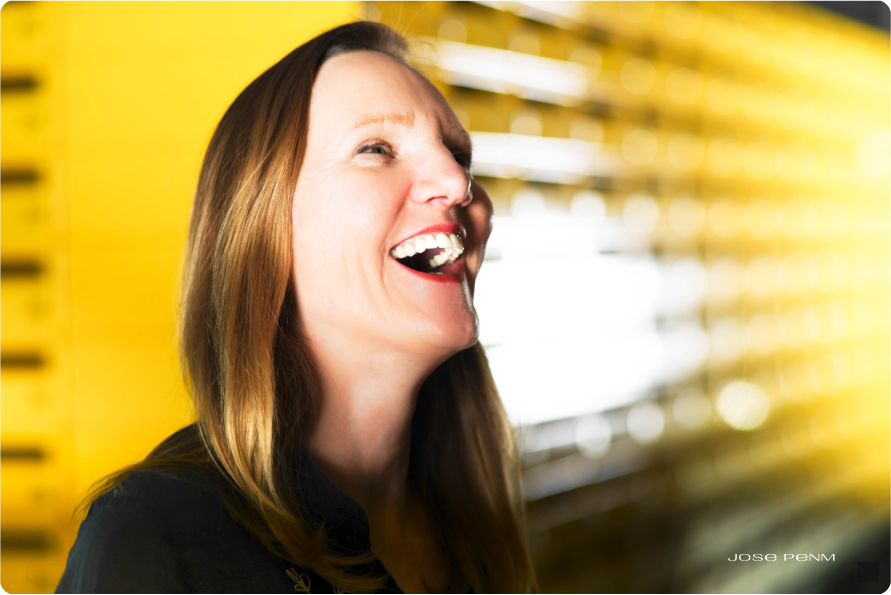 Woman laughing with a blurred yellow background